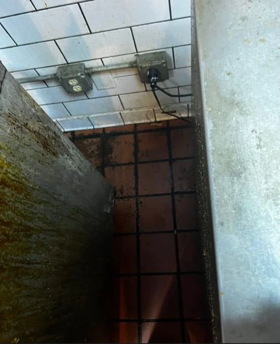 Grease-covered commercial kitchen wall and floor before a cleaning in Tampa, FL